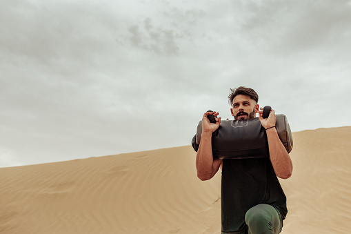 Handsome young man working out in the desert