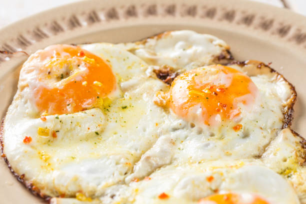 istock Homemade fried eggs on the plate above wooden table 1218615409