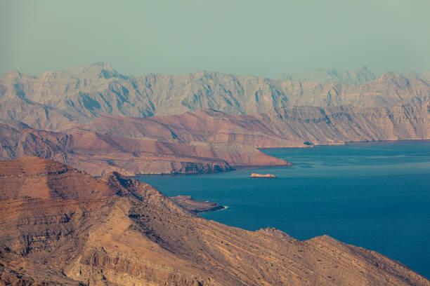 Sultanate of Oman. Coastline of Oman gulf, rocks and fisher boat at early morning near city Muscat. View from Al Bustan beach