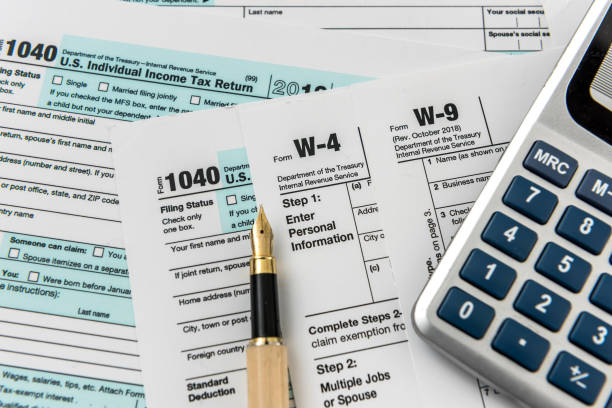istock Tax form, pen and calculator at office desk 1218619246