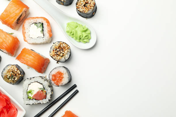 sushi-rollen und essstäbchen auf weißem hintergrund, platz für text. japanisches essen - chopsticks soybean japanese cuisine blue stock-fotos und bilder