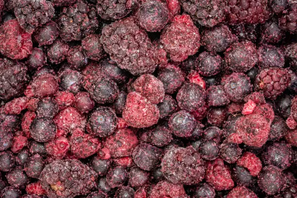 frozen mixed berries closeup background - blueberry, raspberry and blackberry