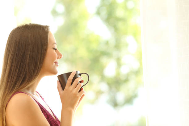 istock Satisfied woman smelling coffee cup at home 1218620549