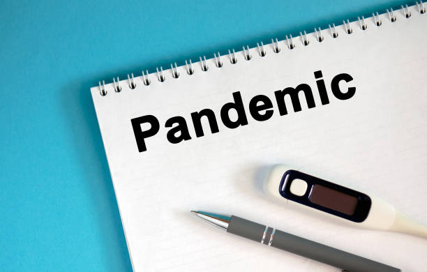 istock Pandemic - text on a notepad. Lie a pen and a medical thermometer 1218620735
