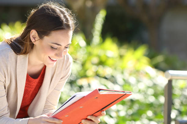 istock Happy student girl with folder studying in a park 1218620966