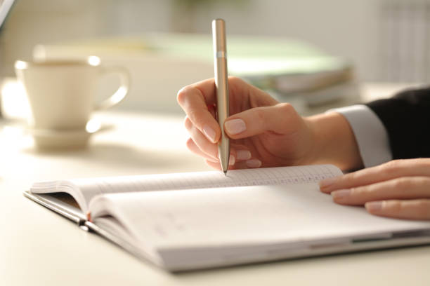 istock Executive hands writing on agenda at the office 1218621108
