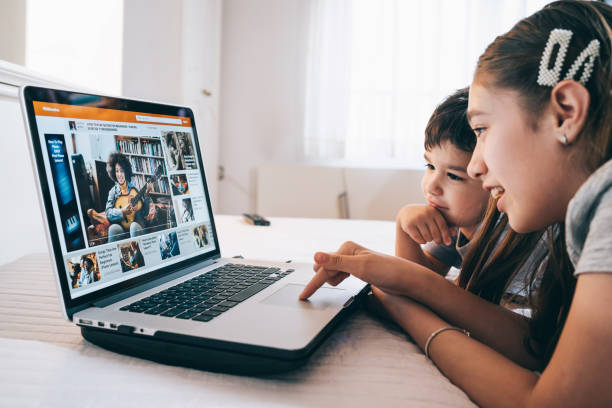 istock Children watching a guitar video online lesson at home in isolation using laptop 1218623712