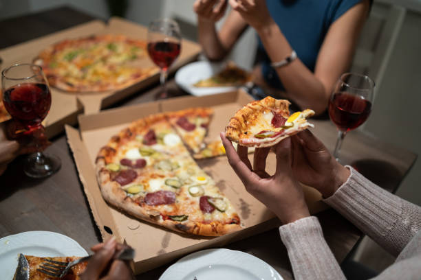 istock Girlfriends eating pizza and talking at home party 1218623996