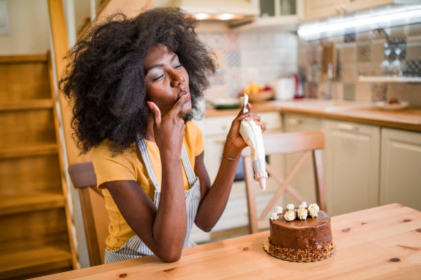 istock Afro women decorating a cake at home 1218624031