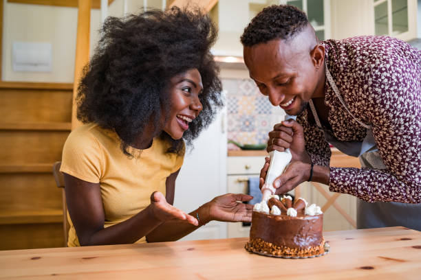 istock Couple in love decorating a cake at home 1218624037