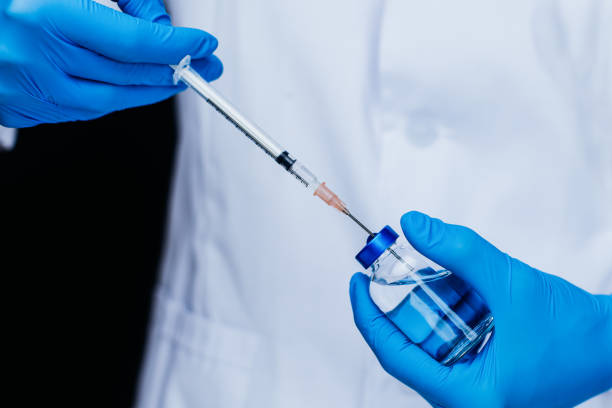 istock Doctor is holding syringe and vaccine 1218625889