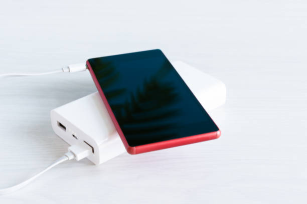 istock Smartphone wireless charging with power bank on white wood background. 1218627277