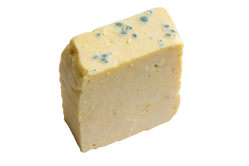 Mold growing on a block of chedder cheese isolated on a white background