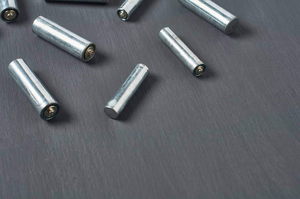istock Scattered old dirty batteries aa or aaa size on dark concrete desk. Recycling concept. Save environment. Alternative energy 1218630241