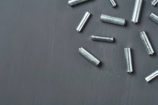 istock Scattered old dirty batteries aa or aaa size on dark concrete desk. Recycling concept. Save environment. Alternative energy 1218630250