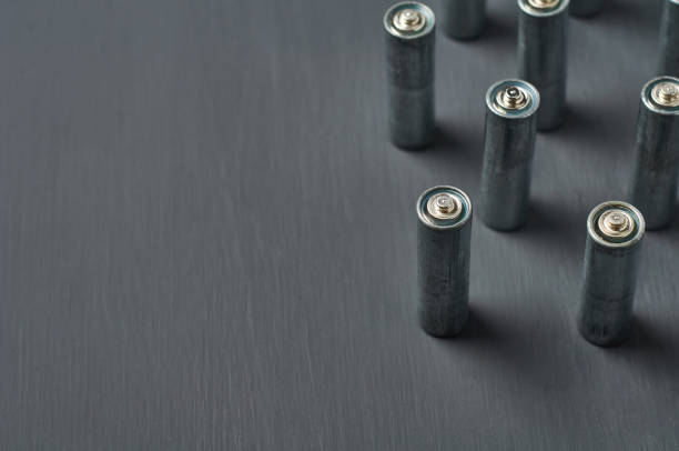 istock Old dirty batteries aa or aaa size on dark concrete desk. Recycling concept. Save environment. Alternative energy 1218630256