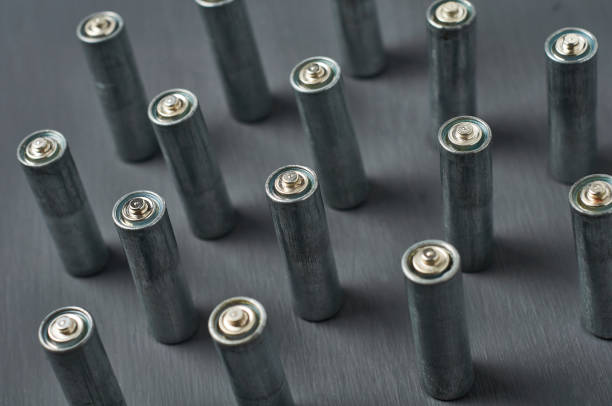 istock Old dirty batteries aa or aaa size on dark concrete desk. Recycling concept. Save environment. Alternative energy 1218630285