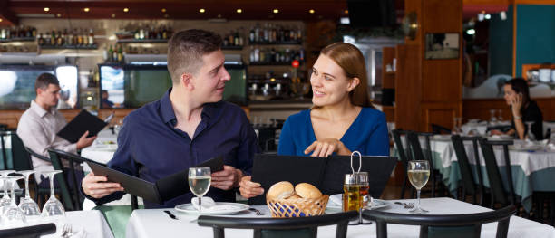 istock Cheerful man and woman reading menu 1218633816