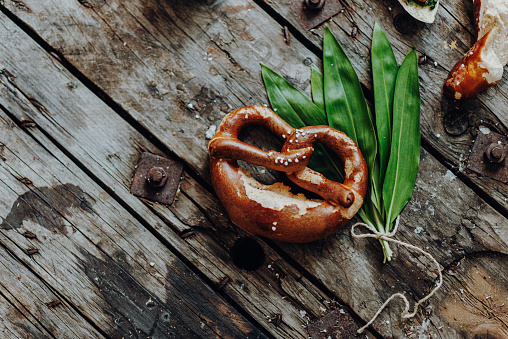 Fresh Wild Garlic Pesto or Ramsons with Bavarian Pretzels on a rustic wooden table – Bavarian 
