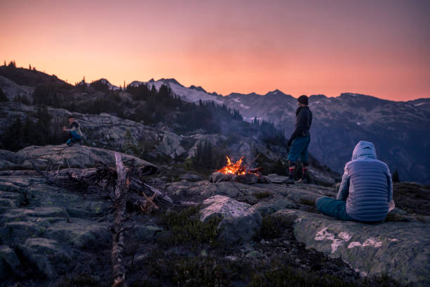 夕暮れ時に山の上にキャンプファイヤーの近くの友人。 - friendship camping night campfire ストックフォトと画像