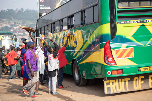 Mubende, Uganda - January 20th, 2020: Unidentified vendors sell snacks for bus passengers on a road in Mubende, Uganda. Selling snacks for passengers on roads is usual kind of small business in Uganda.