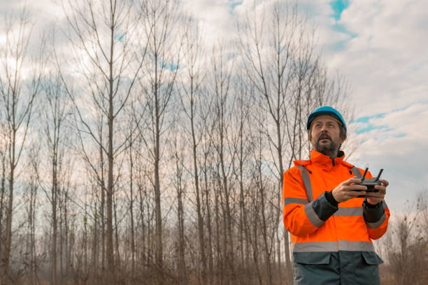 Forestry technician flying a drone with remote controller Forestry technician flying a drone with remote controller in woods and making aerial photos of forest reforestation aerial stock pictures, royalty-free photos & images