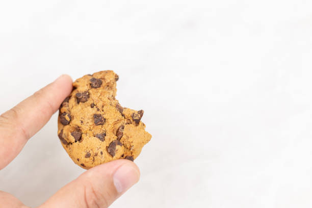 istock Sliced choco biscuit in the hand above white background 1218641964