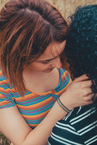 istock Intimate moment between two lesbians, one with a shirt with the lgbt colors - Image 1218642598