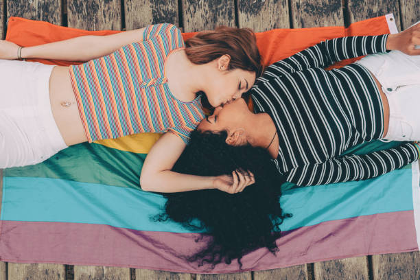 симпатичные лесбийские пары, лежащие вместе на ковре - изображение - lesbian homosexual kissing homosexual couple стоковые фото и изображения