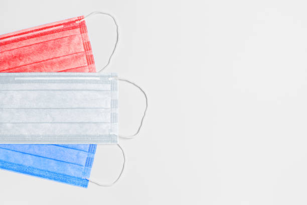 on the left are 3 medical masks of red, white and blue colors on a light background. masks are collected in the flag of the Netherlands. medicine concept in the Netherlands. coronavirus outbreak in the Netherlands. Pandemic in the Netherlands. copy space. flat lay a la izquierda hay 3 máscaras médicas de colores rojo, blanco y azul sobre un fondo claro. máscaras se recogen en la bandera de los países bajos. concepto de medicina en los países bajos. coronavirus en los países bajos. pandemia en los países bajos