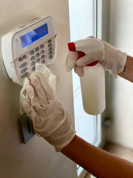 istock Women disinfecting alarm display at home 1218646643
