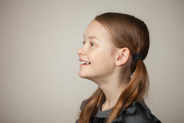 studio portrait of a 9 year old girl on a gray background stock photo