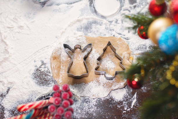 istock cookie cutters herringbone and angel lie on shortcrust pastry on table covered with flour next to tree and candy 1218648739