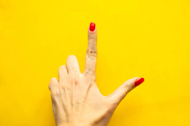 istock Woman's hand shows the point gesture over bright yellow background. Minimal concept. Copy space for the text 1218648761