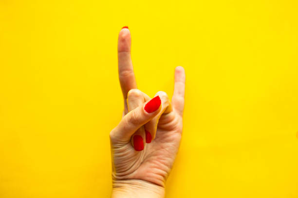 istock Woman's hand shows a gesture Rock over bright yellow background. 1218648785