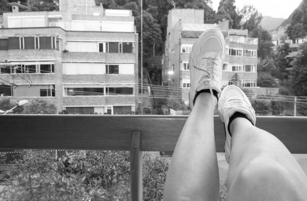 Activities that take place during the isolation by COVID-19\nView of the street from a window, different leg positions, looks or appears for a long time sitting in front of the window, Sitting relaxed
