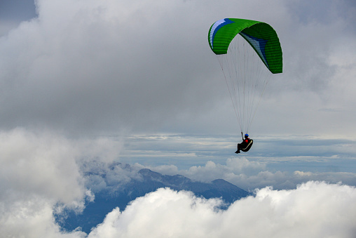 Paragliding in the sky. Paraglider tandem flying over the sea with mountains at sunset. Aerial view of paraglider and Blue Lagoon in Oludeniz, Mugla, Turkey.