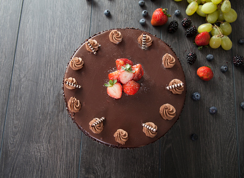 Chocolate cake with icing and fresh summer berry isolated on background
