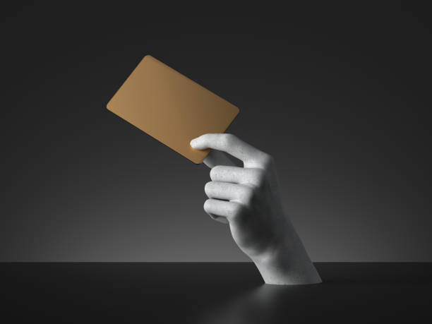 istock 3d render, mannequin hand holding blank golden card or ticket isolated on black background. Payment metaphor. Modern minimal concept, simple clean design. Concrete sculpture. Artificial human limb 1218652589