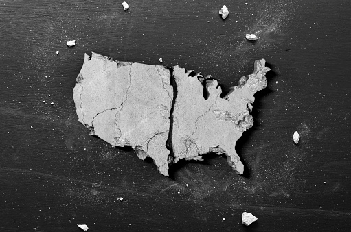 Crumbling Shape of America - Do to coronavirus quarantine the USA economy and housing market crumbling concept on black background.
