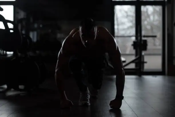 Silhouette Strong Muscular Men Kneeling On The Floor - Almost Like Sprinter Starting Position