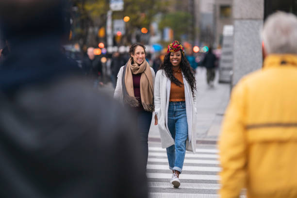 duas lindas mulheres atravessando rua movimentada da cidade - toronto street canada city - fotografias e filmes do acervo