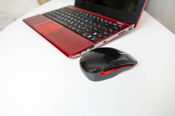 istock A modern red laptop and a mouse standing on white table, working space for business 1218662058