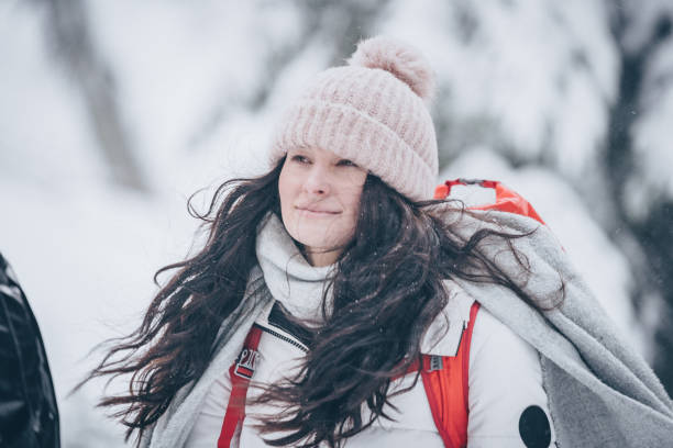 istock Young woman hikes through snowy forest 1218664207