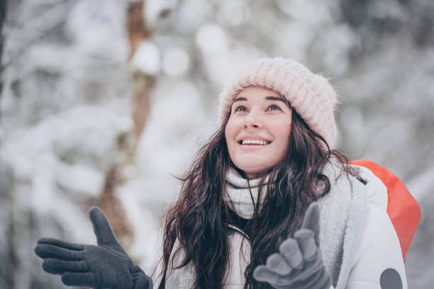 istock Young woman hikes through snowy forest 1218664362