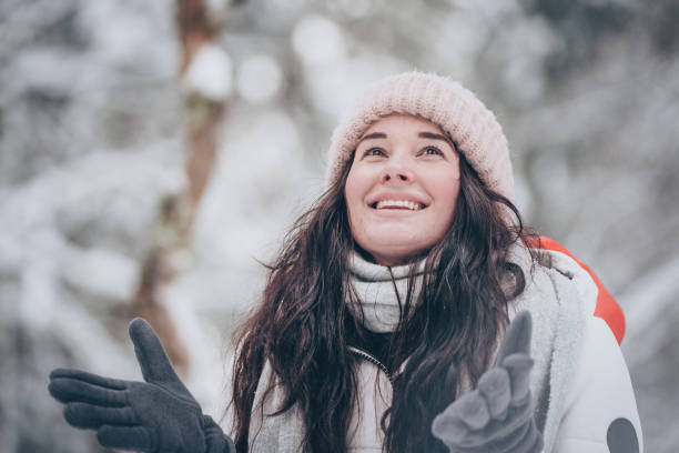 istock Young woman hikes through snowy forest 1218664896