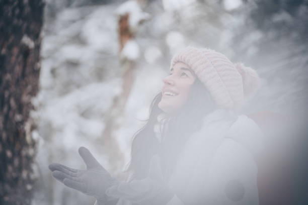 istock Young woman hikes through snowy forest 1218664897