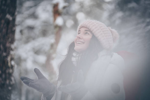 istock Young woman hikes through snowy forest 1218664904