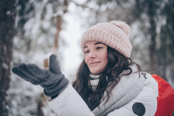 istock Young woman hikes through snowy forest 1218664913