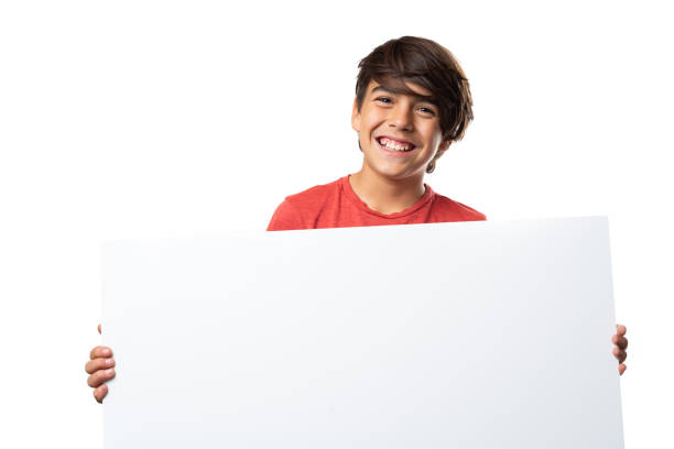 istock Cute latinx hispanic boy smiling, holding blank sign, on white background 1218665198